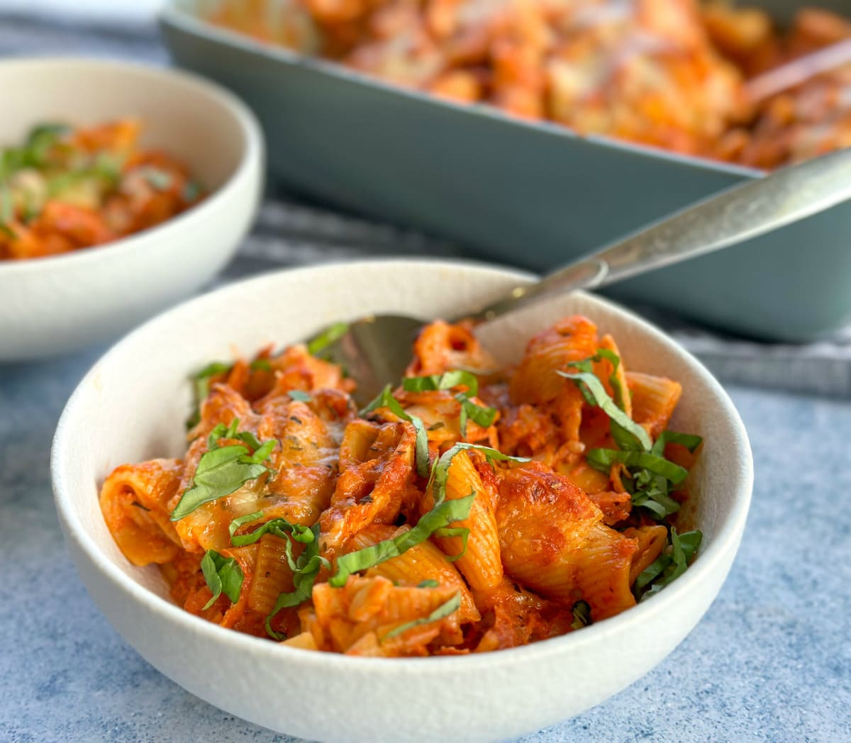 Bowl of creamy tomato pasta bake with hidden veges, chicken and basil 