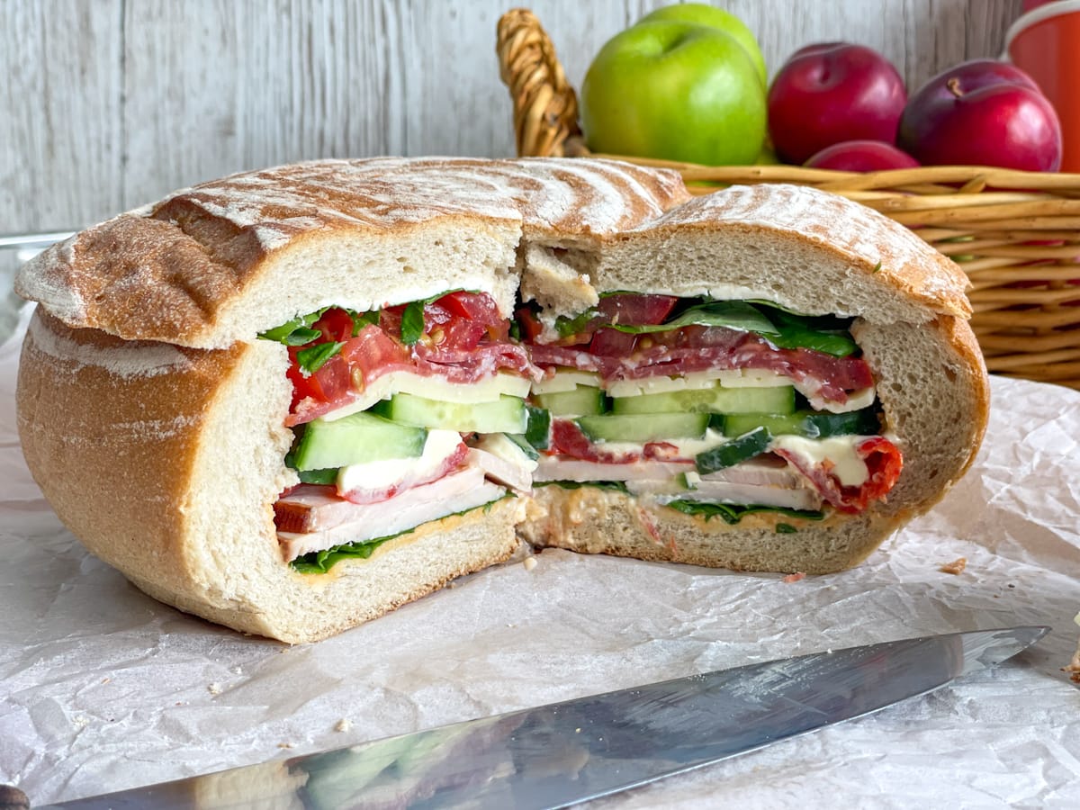 A cross section of a stuffed layered cob loaf sandwich, showing all the layers of each ingredient