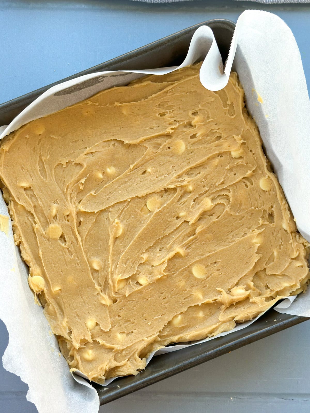 Blondie recipe in a baking paper lined pan ready to go in the oven