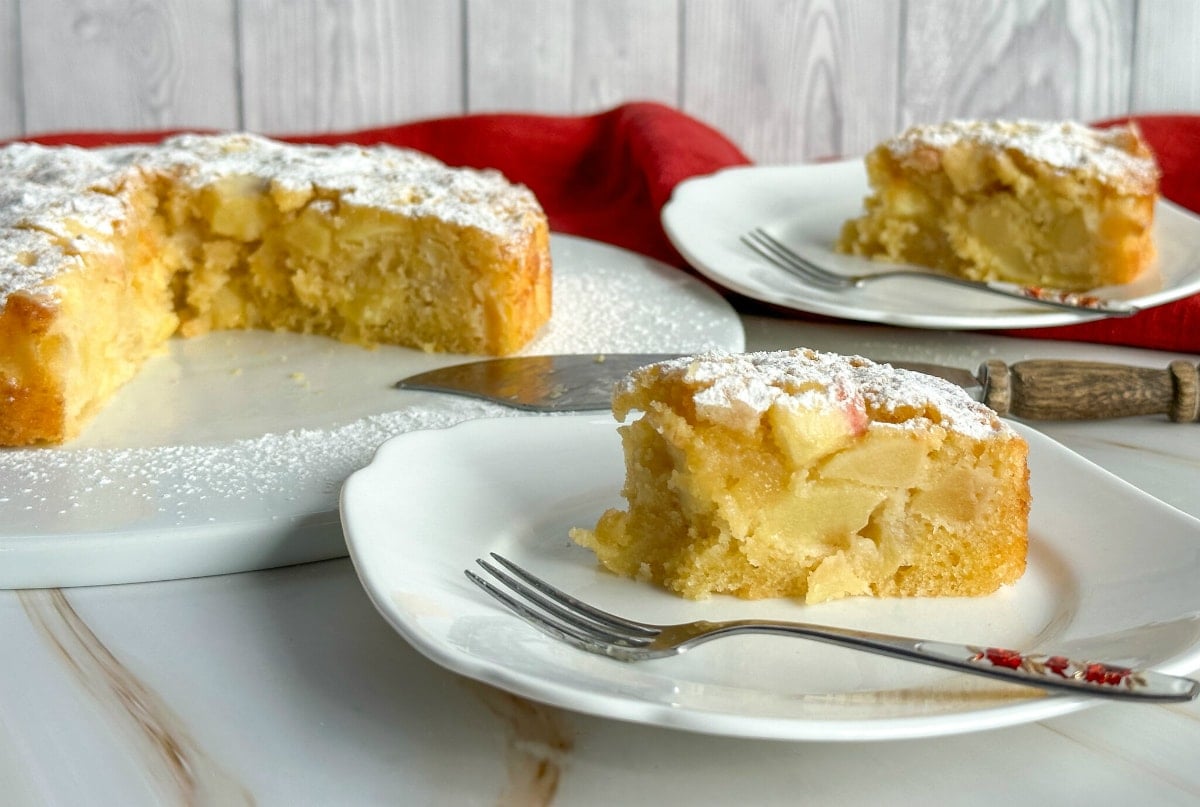 A slice of french apple cake showing the chunks of apple in each slice