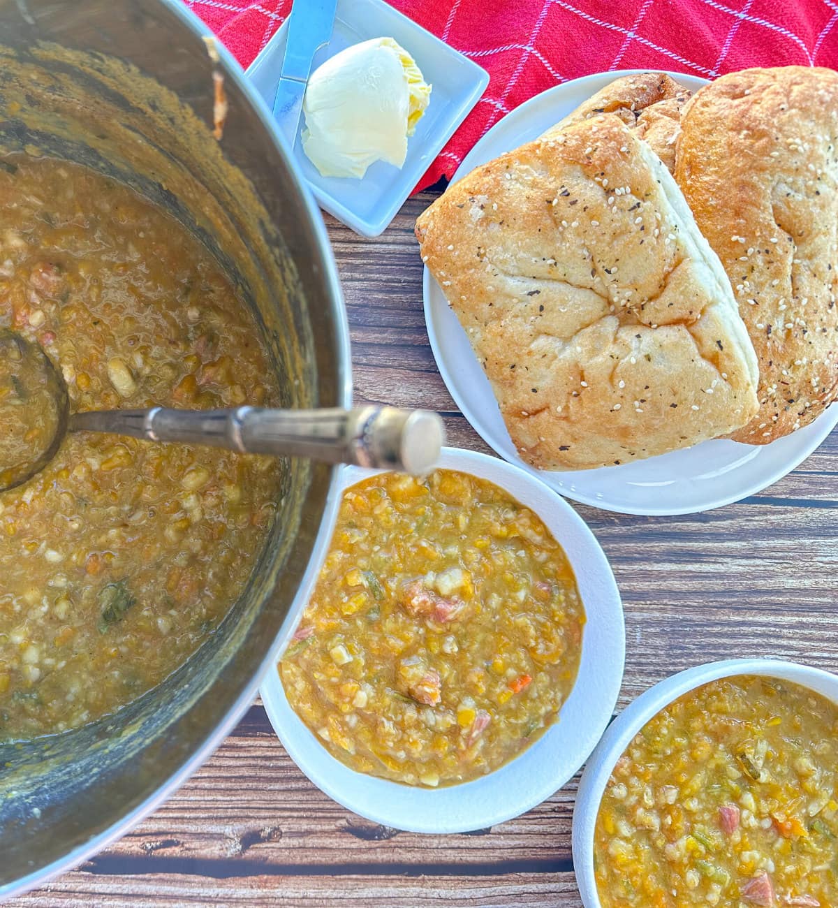 Large soup stock pot with two bowls of vege and bacon soup