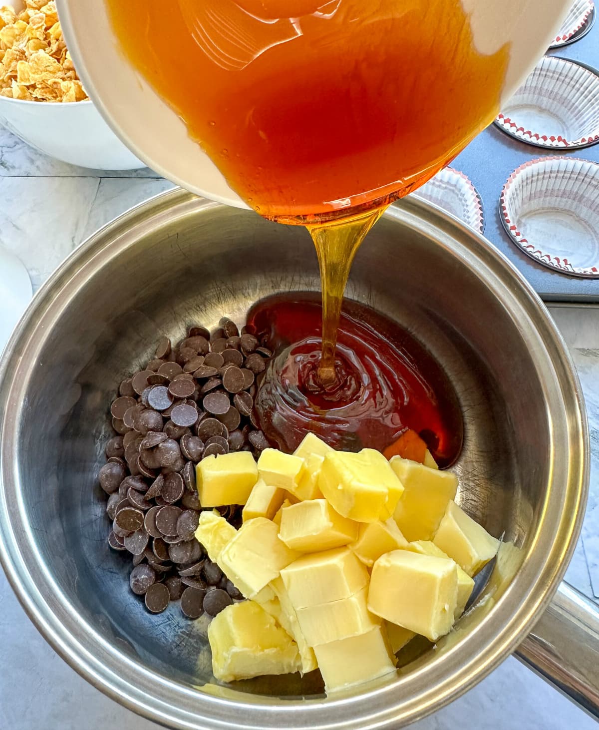 Golden syrup being poured over chocolate and butter in a saucepan