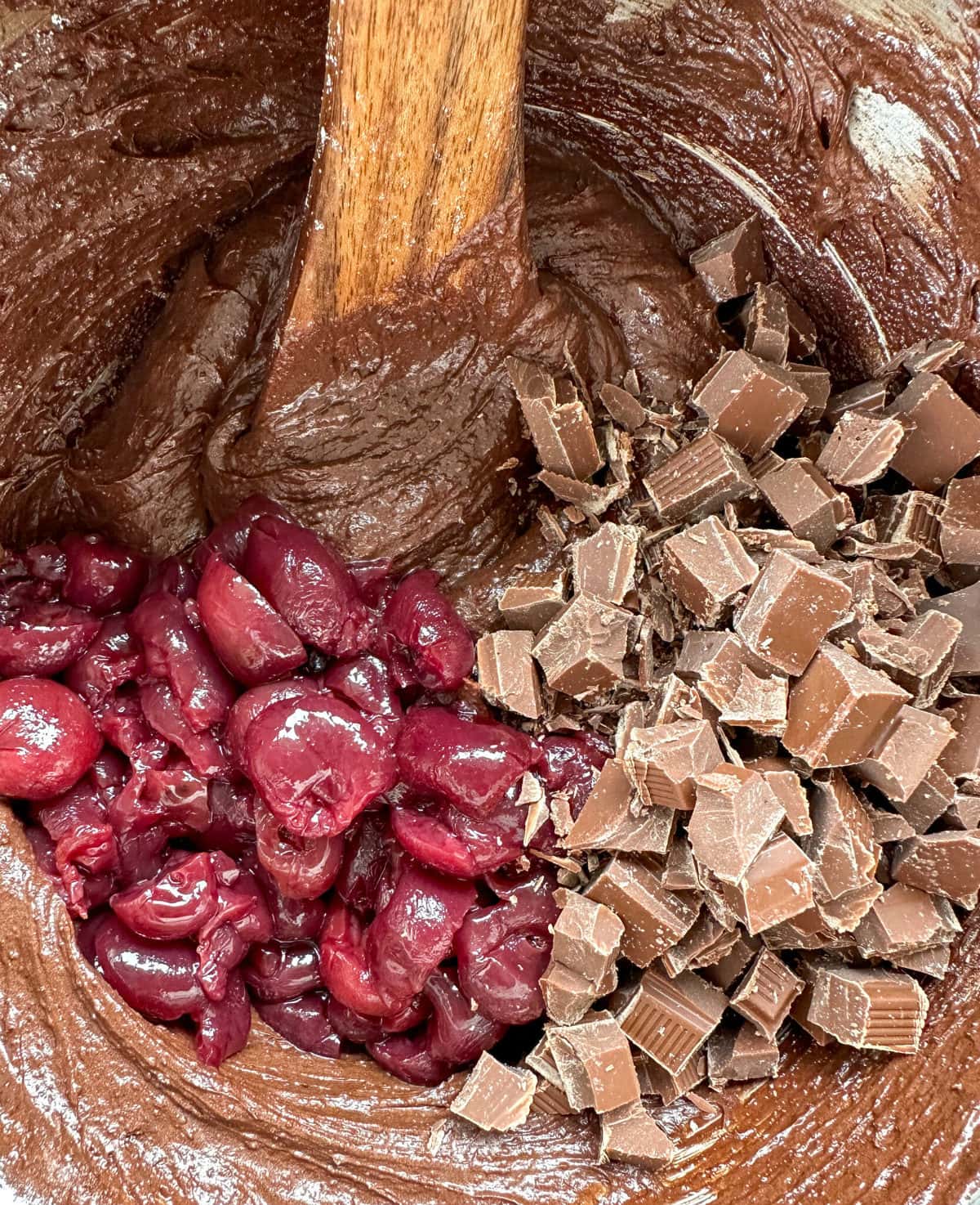 Brownie mixture with chunks of chocolate and cherries