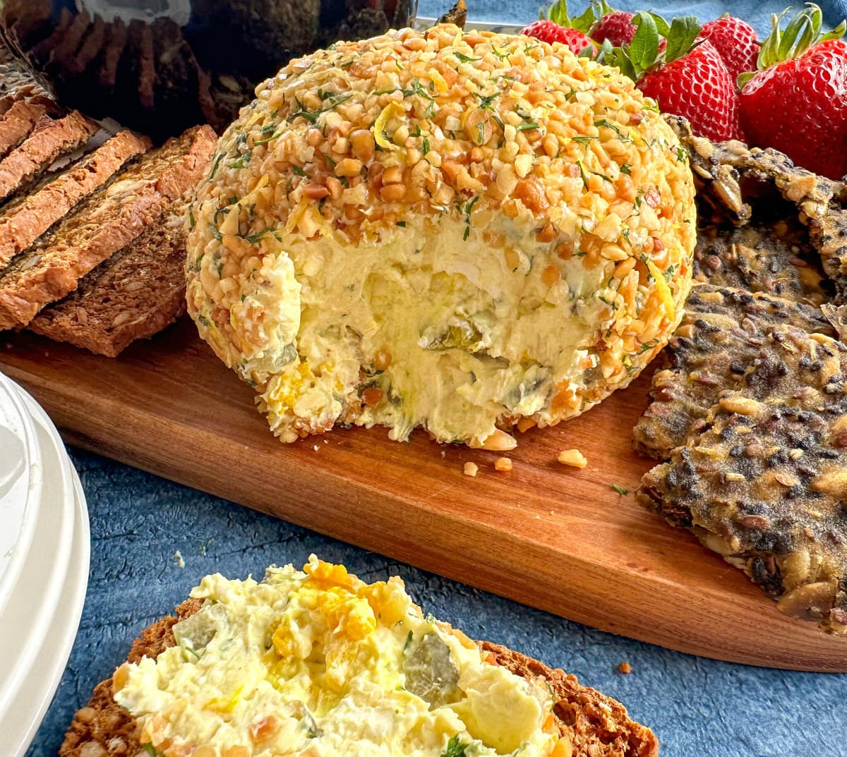 Dill Pickle Cheeseball on a platter with fruits and crackers. 