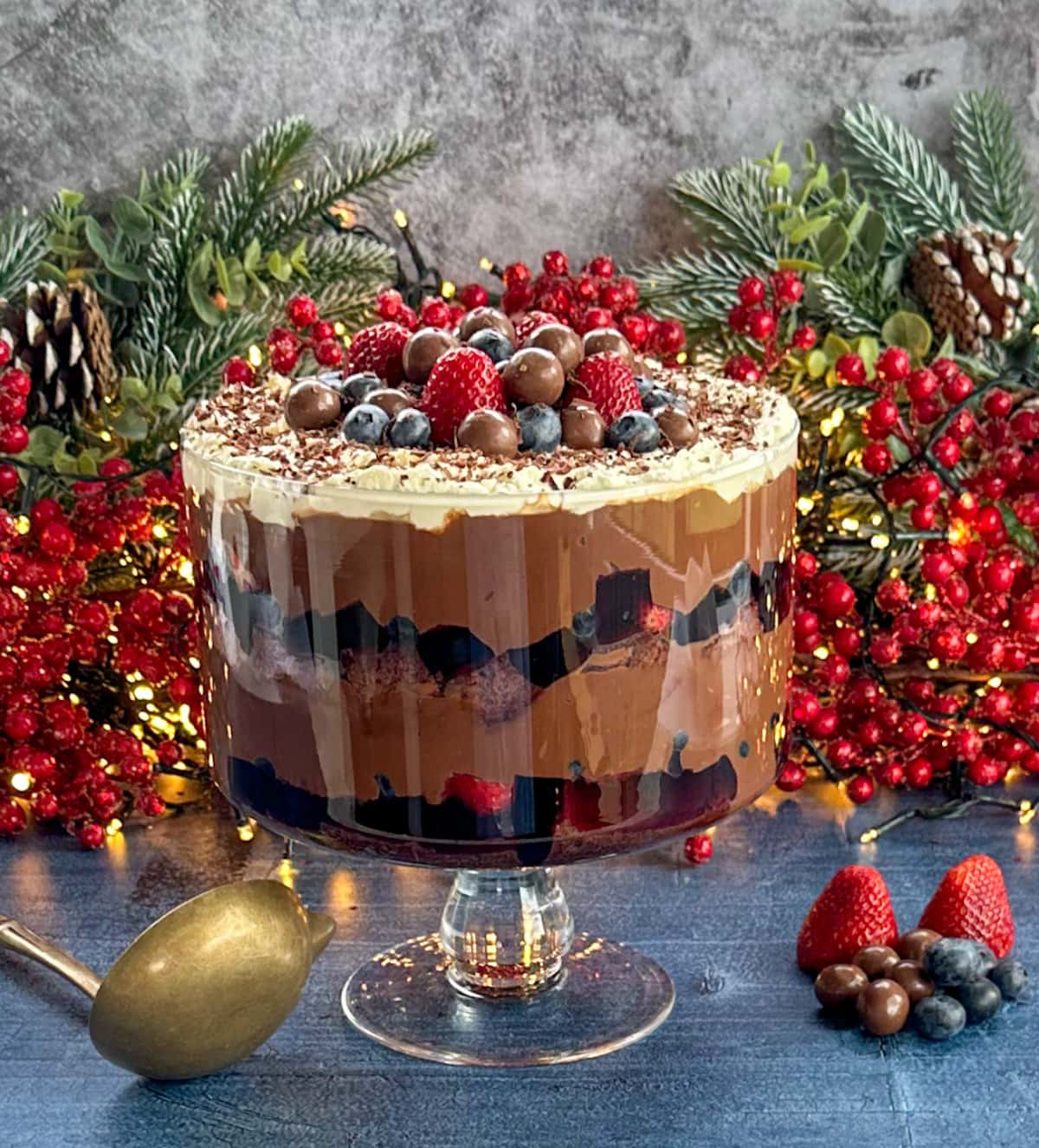 Chocolate layered trifle with chocolate custard set against a festive Christmas backdrop