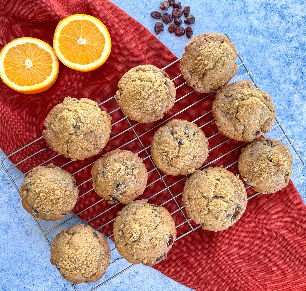 A cooling rack on a red and blue background showing muffins fresh from the oven