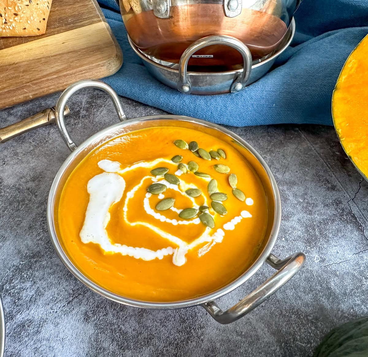 Thick creamy Thai Pumpkin soup, garnished with coconut cream and pumpkin seeds