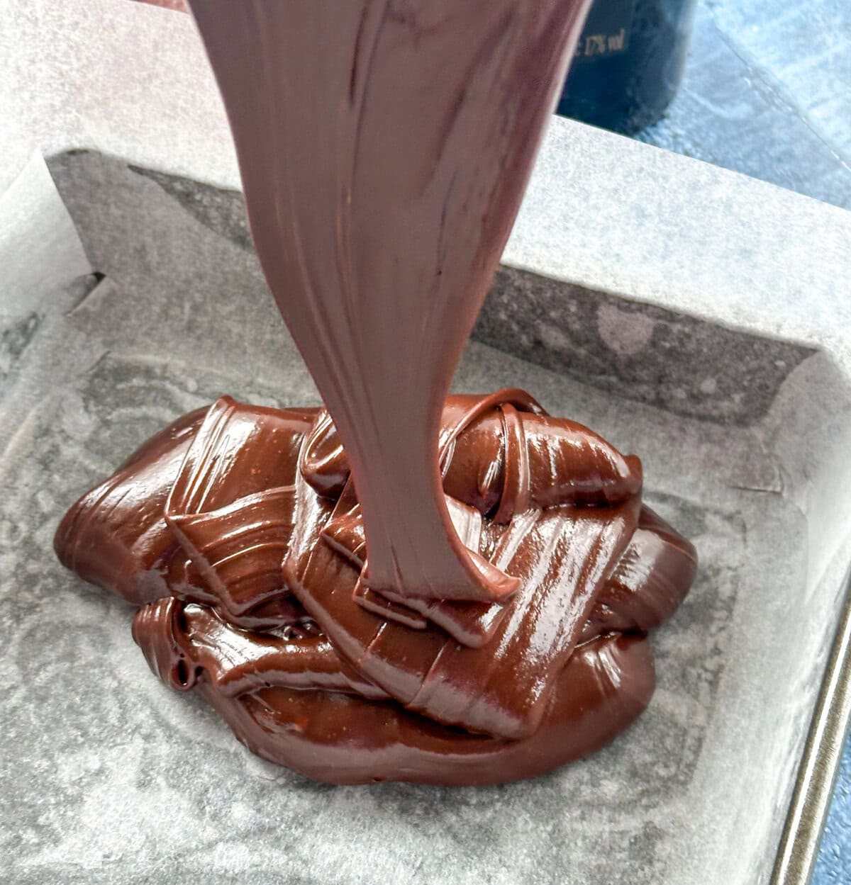 Fudge pouring into a lined pan