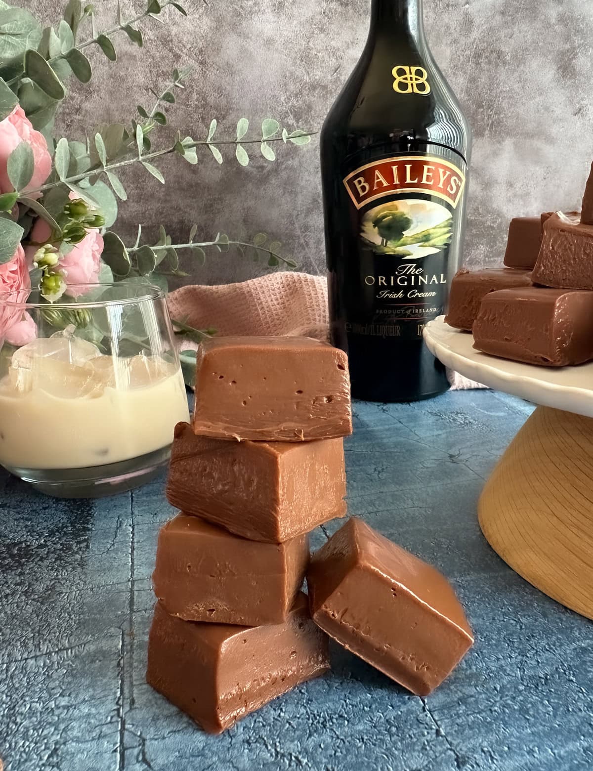 Fudge with a bottle of baileys in the background and a glass of baileys