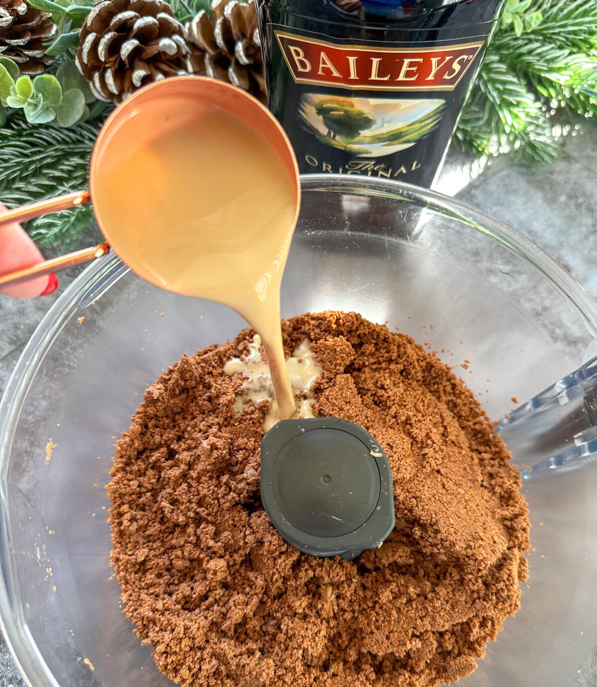 Baileys being poured into crushed Tim Tams 