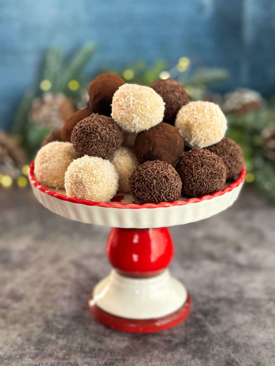 Red and white stand holding a variety of Baileys Tim Tam Truffles with festive background 