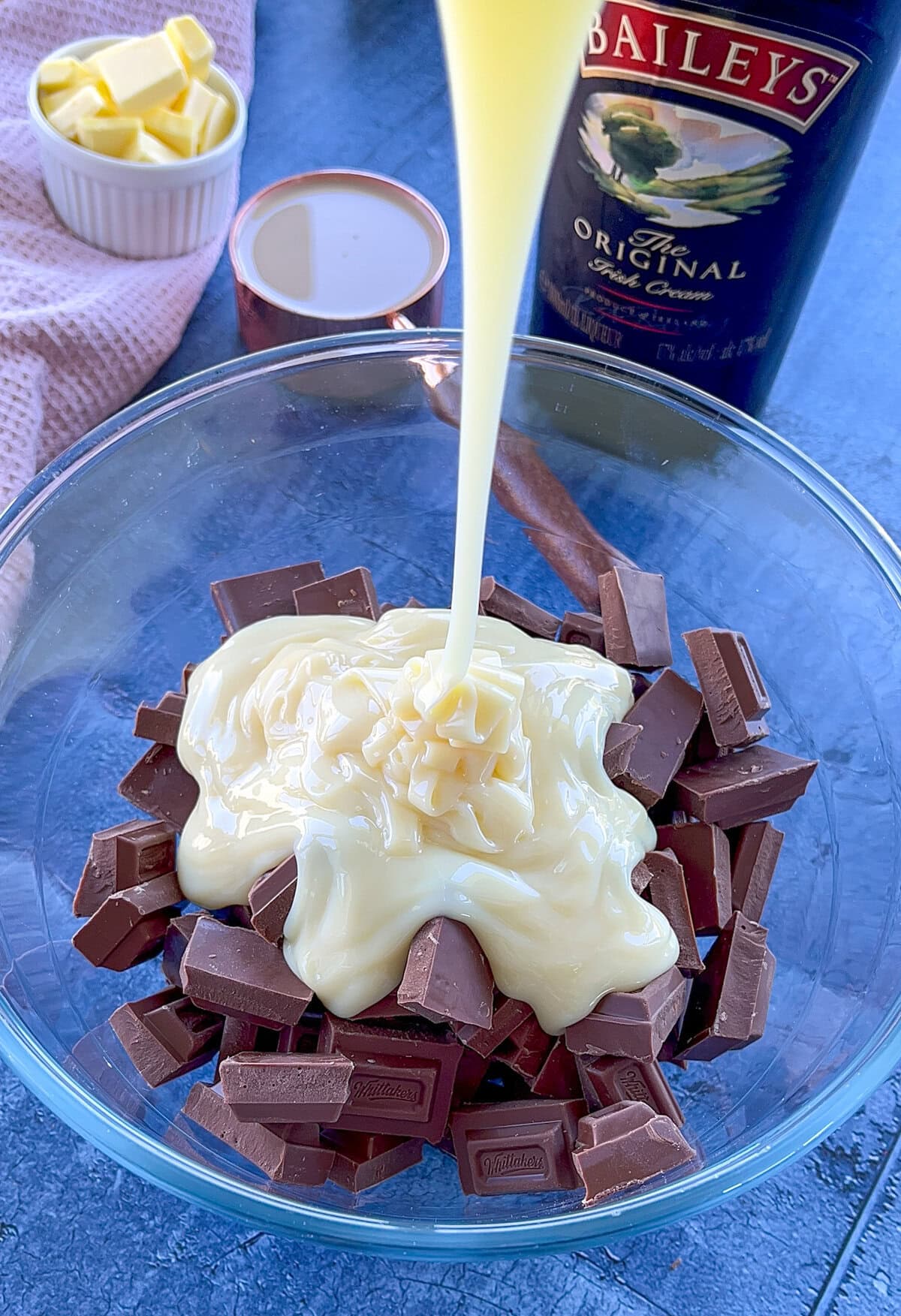 condensed milk being poured into diced chocolate