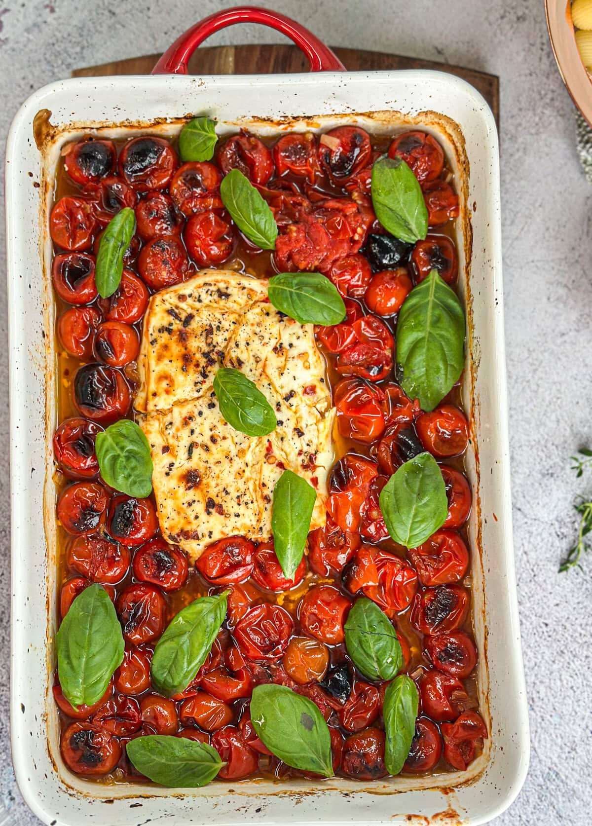 Feta and Cherry tomatoes baked in extra virgin olive oil until golden and bursting with flavour and scattered with basil leaves. 