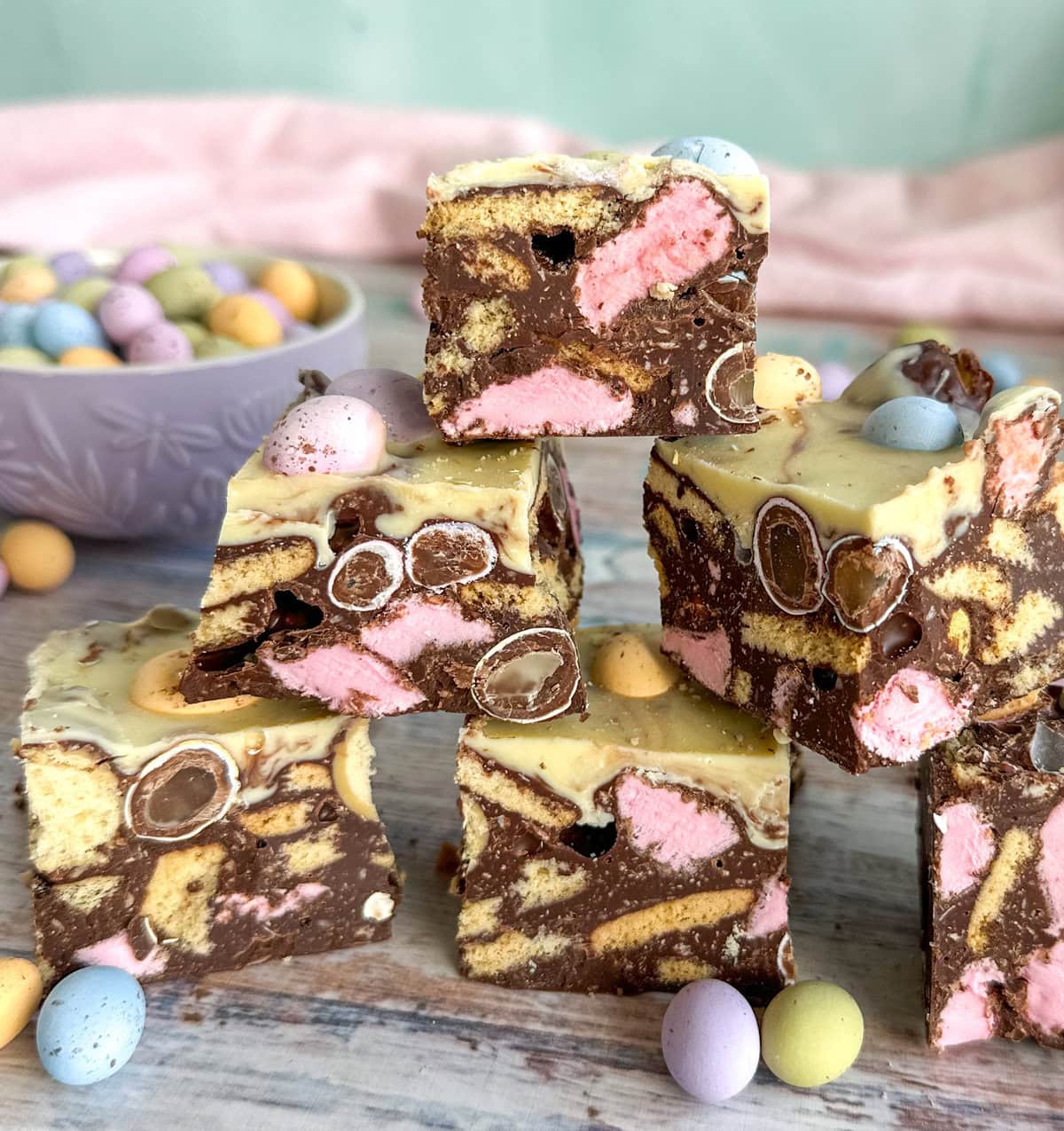 Chunks of Easter Rocky Road stacked on top of each other with mini pastel hard candy easter eggs