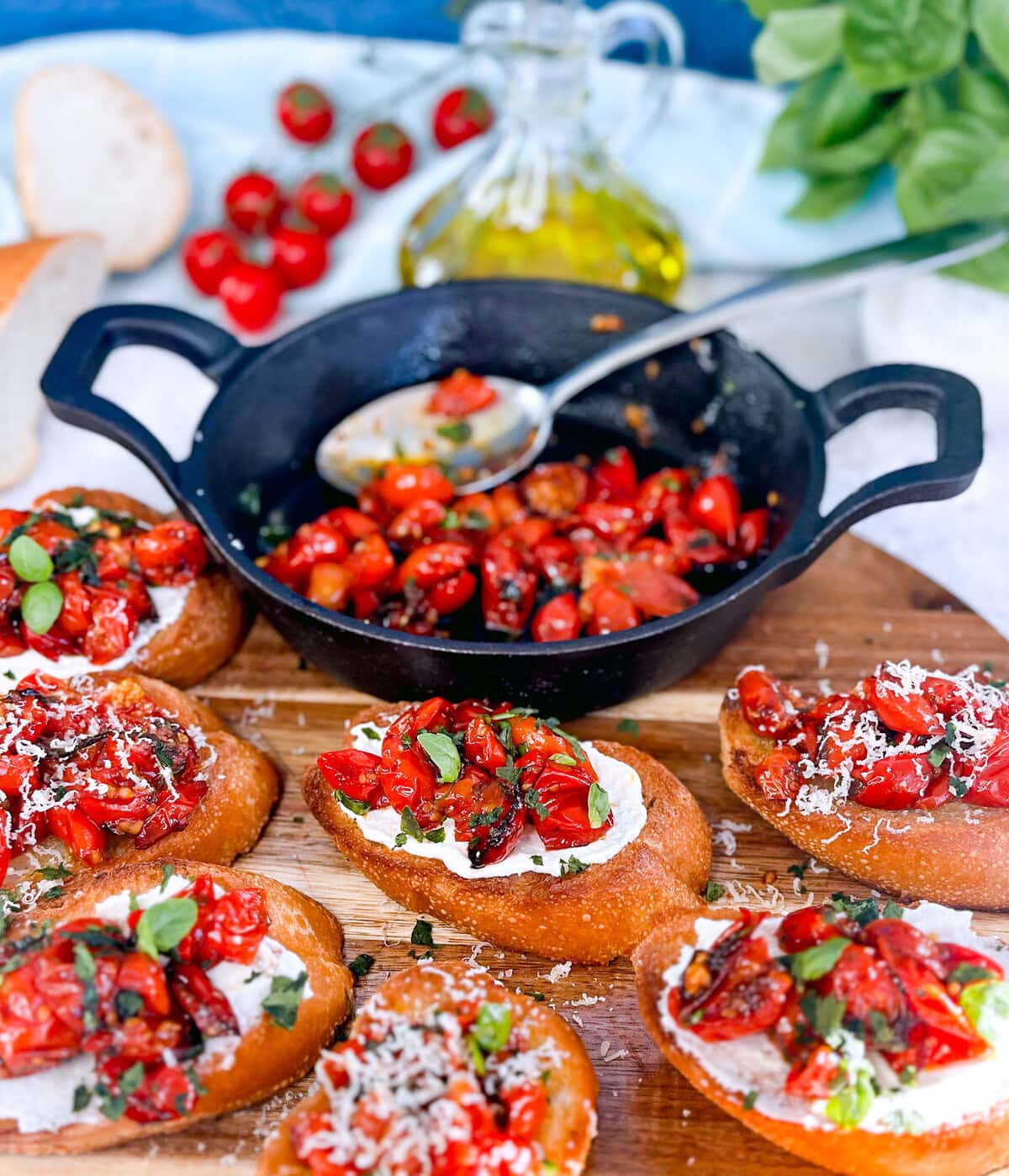 roasted cherry tomatoes in a cast iron pan and some served on golden bruschetta