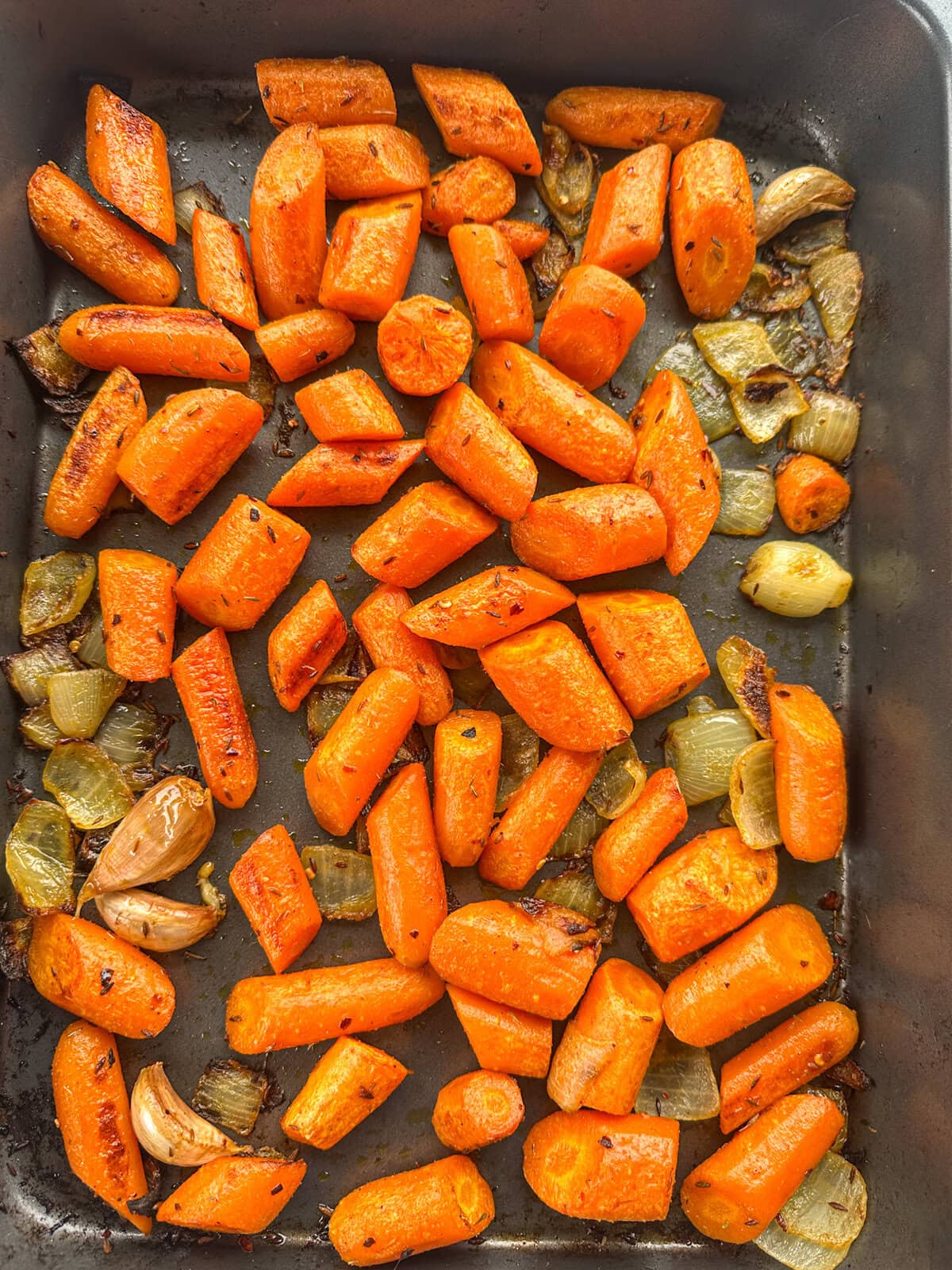 Roasted carrot, garlic and onions in spices and herbs to golden brown