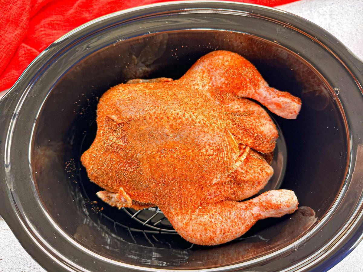 Raw chicken with spice rub in a slow cooker 