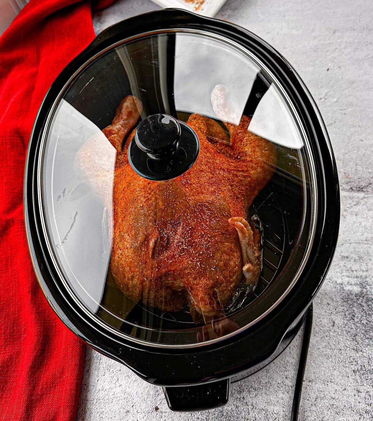 whole chicken in a slow cooker with the lid on