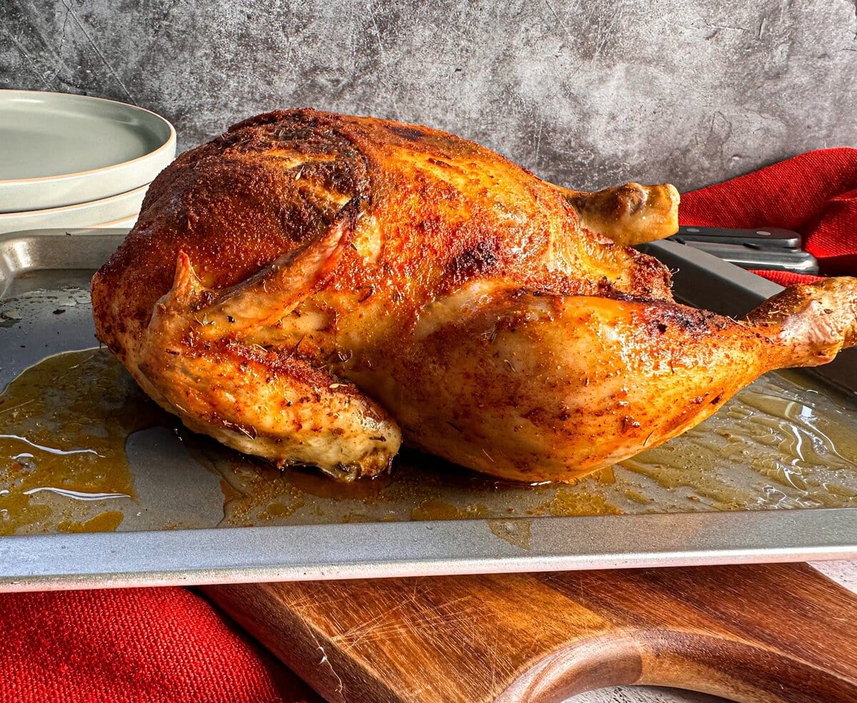 cooked chicken with crispy skin on a roasting dish