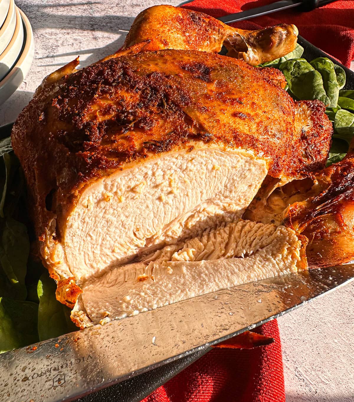 Sliced open whole crispy chicken showing juicy tender chicken breast