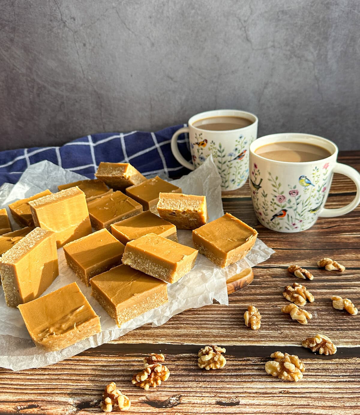 Sunshine shining on a wooden table with coffee and walnut slice and two mugs of coffee