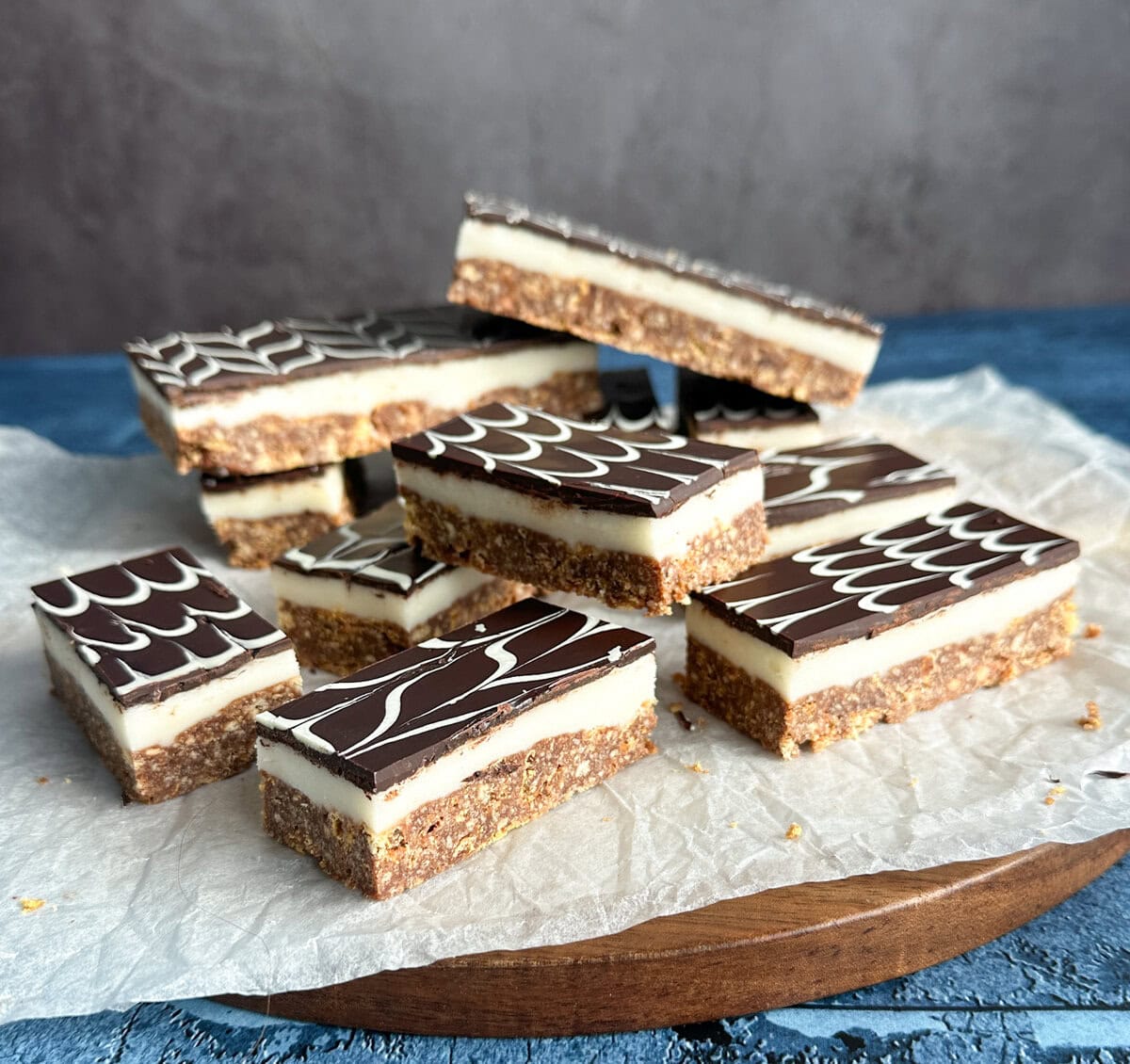 No Bake Peppermint slice, cut into bars on a piece of parchment paper. Topping is a feathered technique of dark chocolate and white chocolate
