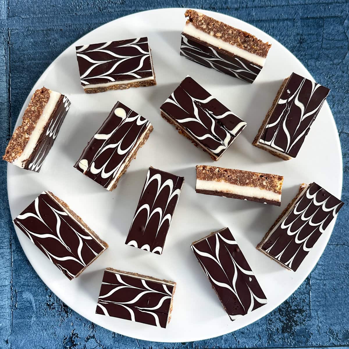 White round plate with pieces of no-bake peppermint slice, cut into bars. 
