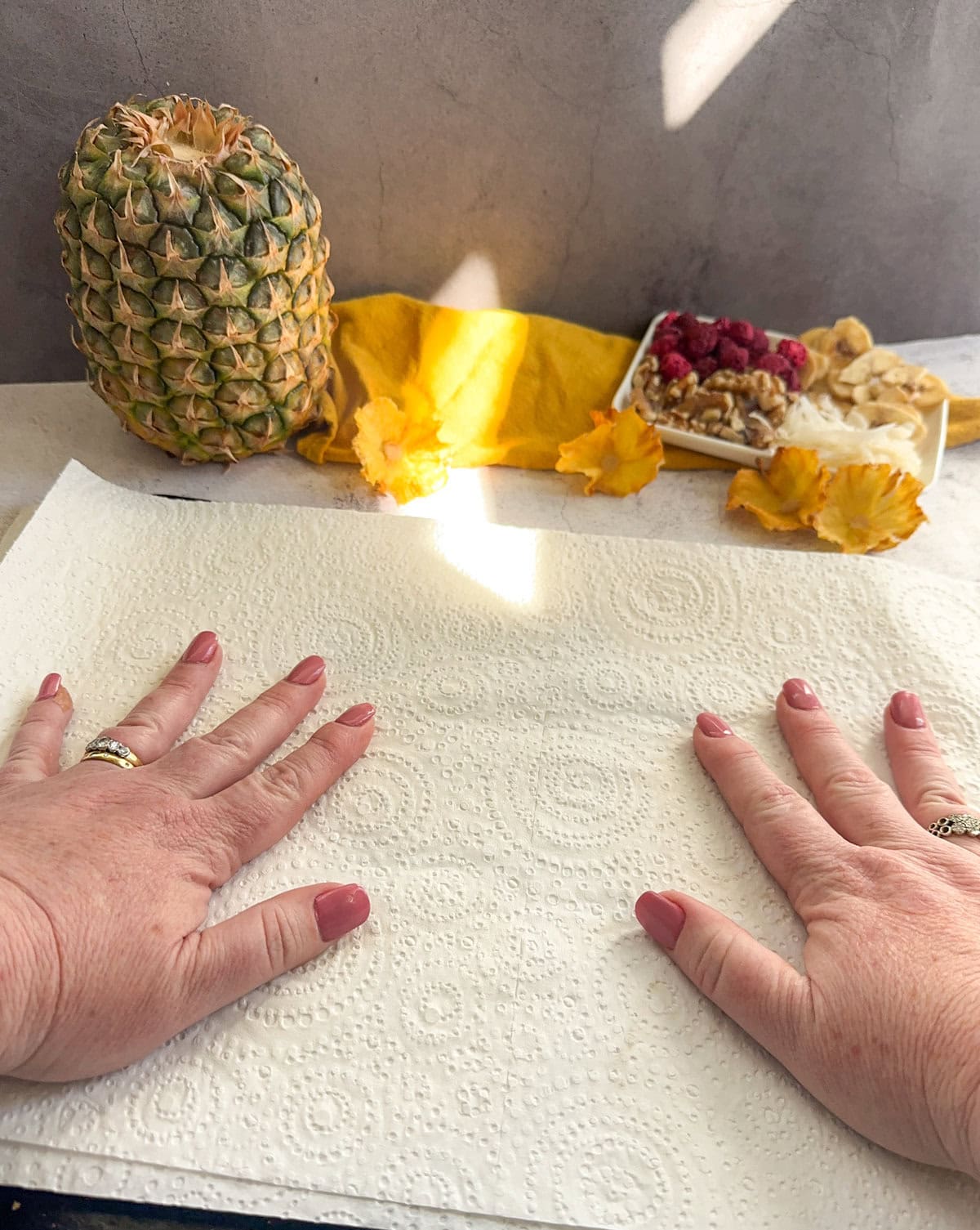 Pressing the paper towels down with my hands to draw out moisture when making pineapple flowers