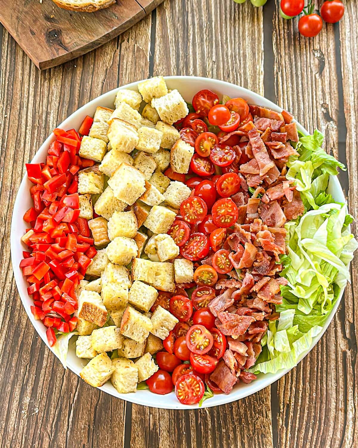 BLT Salad in a white bowl on a wooden table