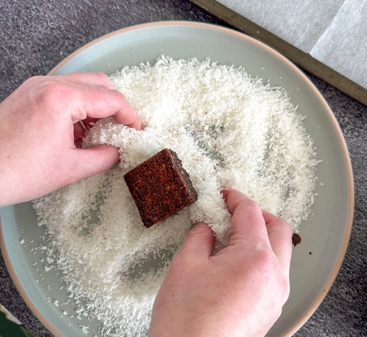 rolling the lamington in coconut