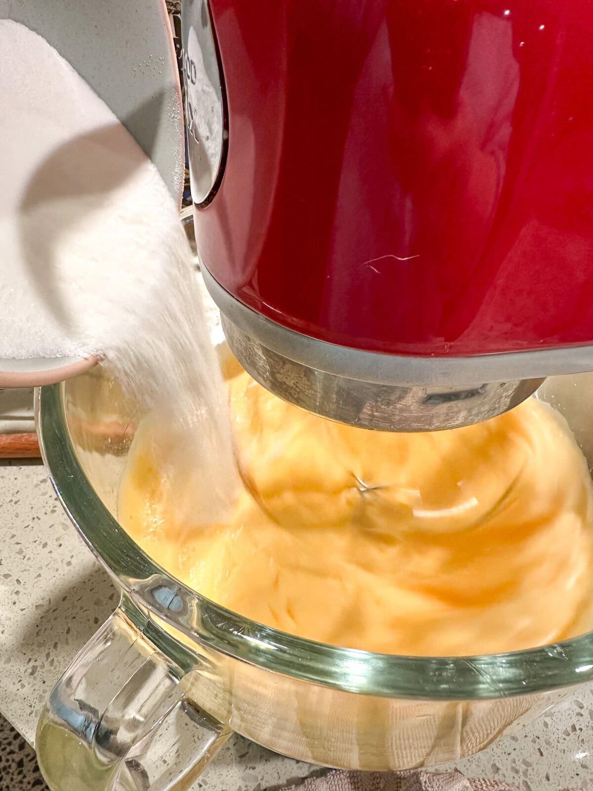 slowly adding caster sugar into eggs in a stand mixer