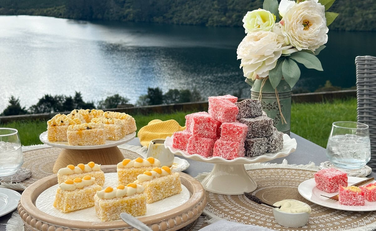 various lamington varieties on a set table with the lake in the background.